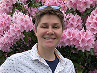 Woman smiling with pink flowers in the background