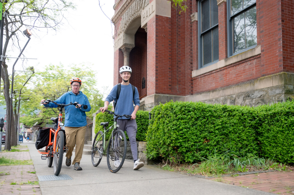 Two people walking next to bikes